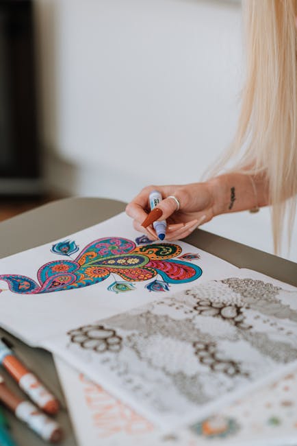 Woman coloring intricate patterns using markers, showcasing creativity and relaxation indoors.